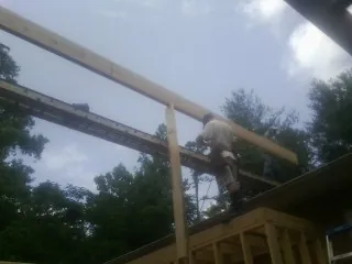 Carpenter setting a ridge beam over a new addition frame — Ice Dam Removal by Roofing Brothers in North Granby