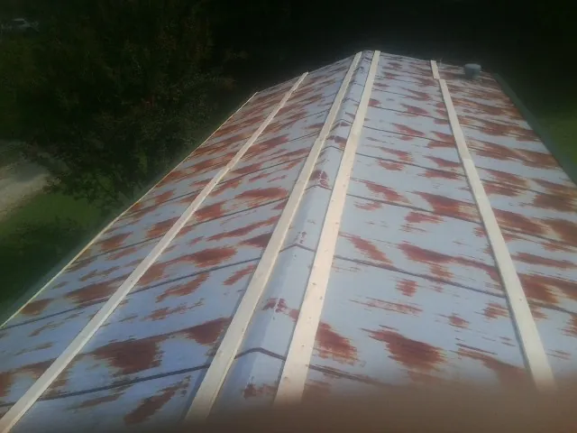 Rusted metal roof panels with new wood purlins before replacement — Storm Damage Roof Repair in North Granby by Roofing Brothers