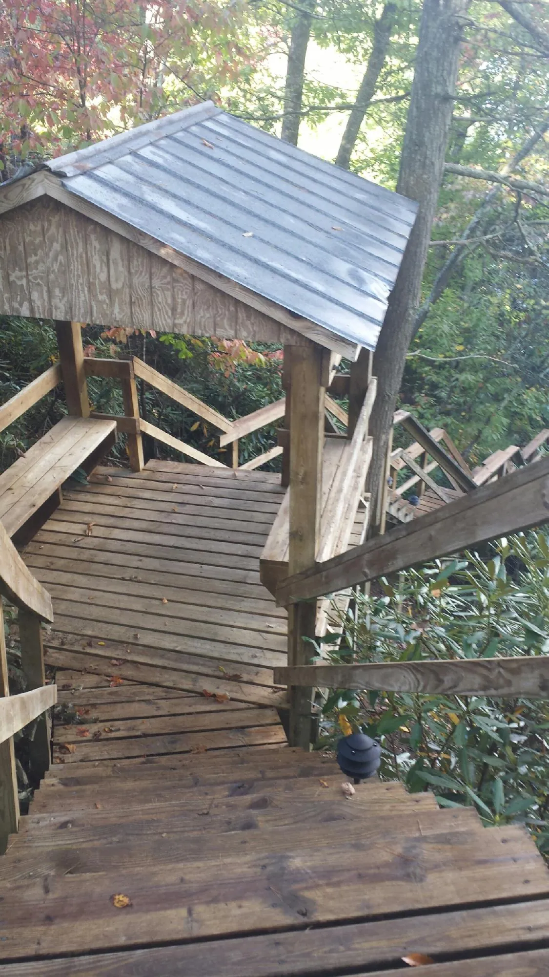 Metal roofed shelter over wooden steps on a wooded walkway — Skylight Repair & Installation work by our crew in North Granby