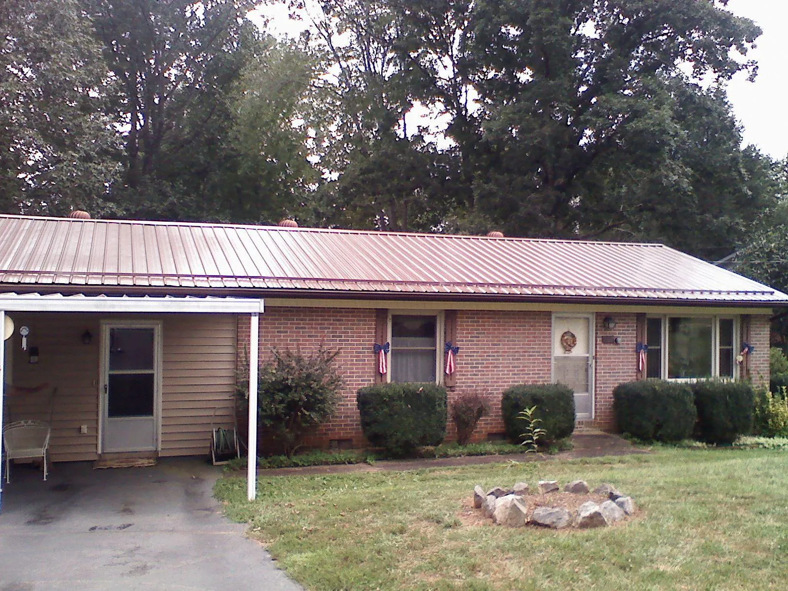 Bronze metal roof and carport on a brick ranch home — Roof Repair work by our crew in North Granby