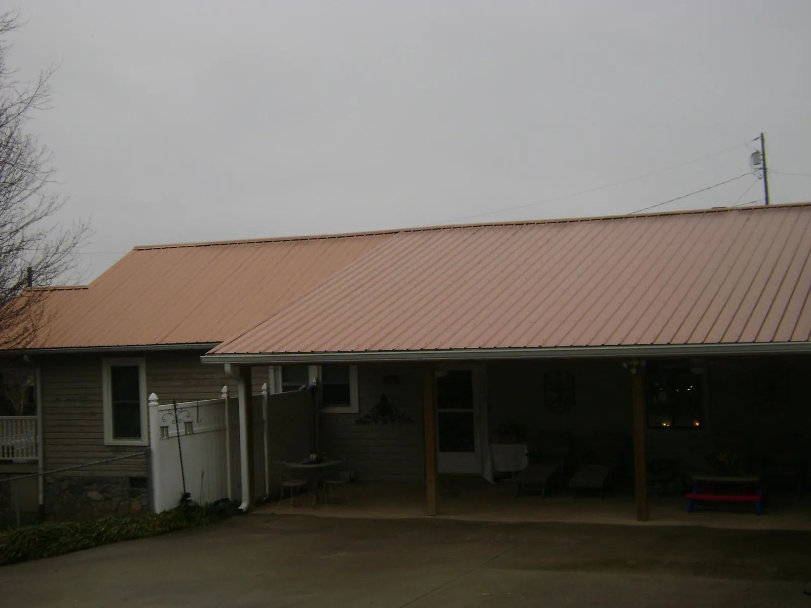 Copper toned metal roof over a wide covered patio in North Granby